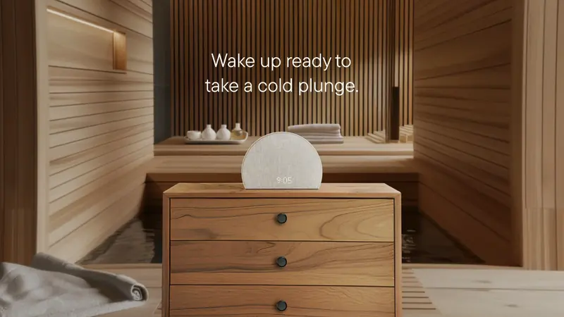 The same alarm clock on a nightstand in a wooden sauna, with the headline “Wake up ready to take a cold plunge.”