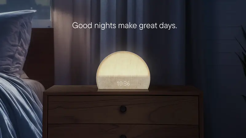 The same alarm clock glowing softly on a nightstand in a dark bedroom, with the headline “Good nights make great days.”